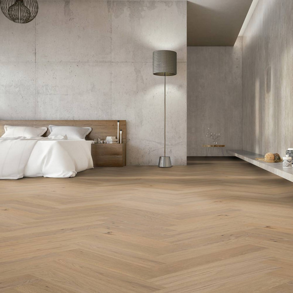 Eichenparkett im Fischgrätmuster mit gebürsteter, geölter Oberfläche. Die hellen Holzplanken zeigen natürliche Maserungen und Knoten. Der Boden vermittelt eine elegante und natürliche Optik.